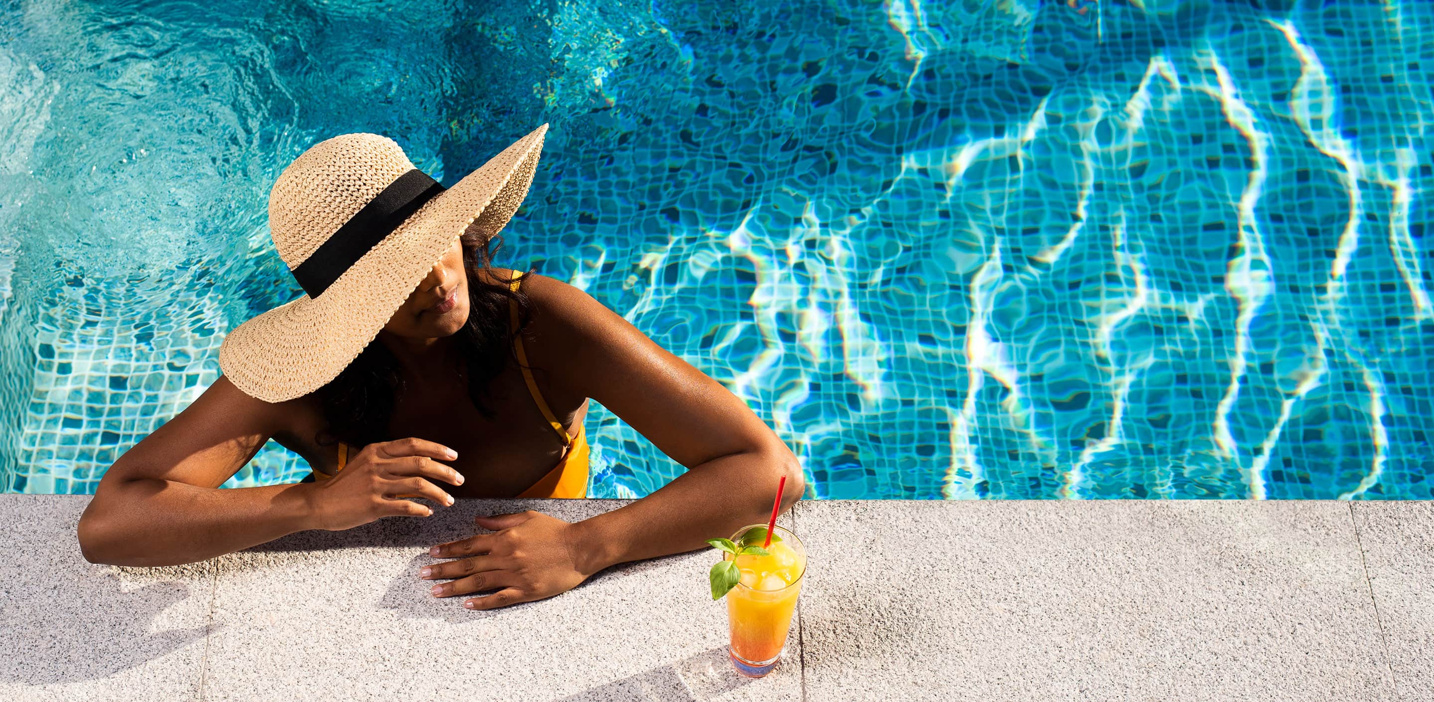 Kvinna med hatt i pool