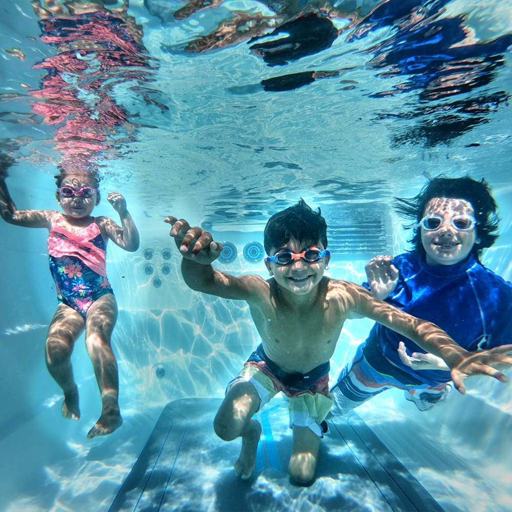 Barn som leker under vatten i året runt pool